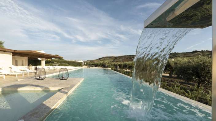 Ein Wasserfall fließt über einen großen Swimmingpool