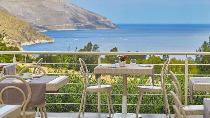 Tisch und Stühle auf einem Balkon mit Blick auf den Ozean