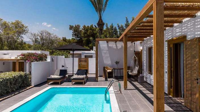 Ein großer Swimmingpool in der Nähe eines weißen Hauses