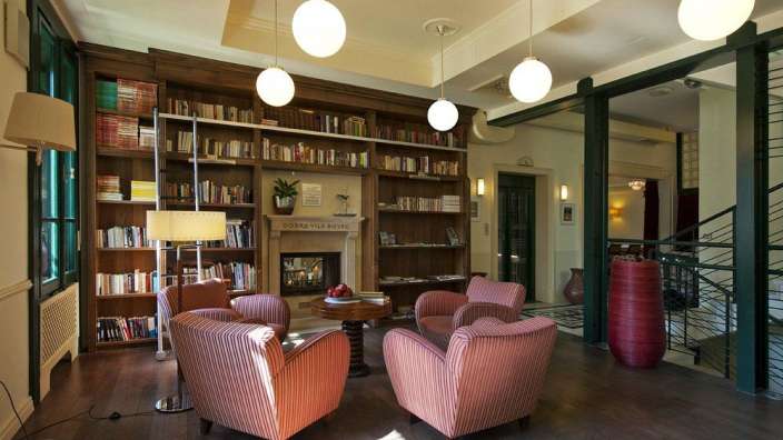 Ein Wohnzimmer mit roten Stühlen und Bücherregalen