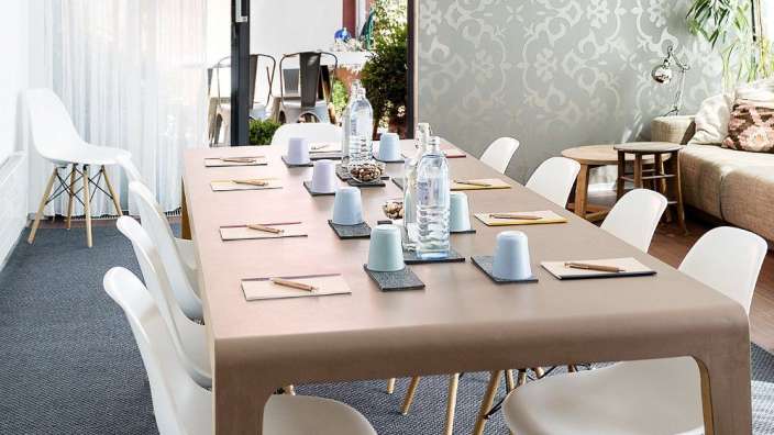 Ein langer Tisch mit weißen Stühlen und Wasserflaschen darauf