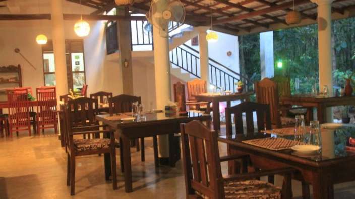 Ein Restaurant mit vielen Tischen und Stühlen und einem Ventilator