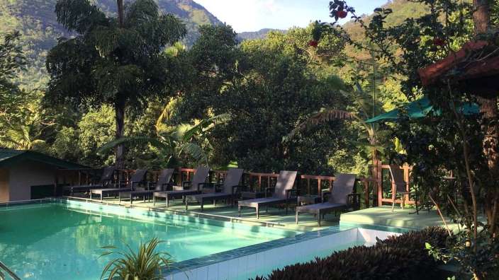 Ein Pool mit Stühlen und einem Berg im Hintergrund