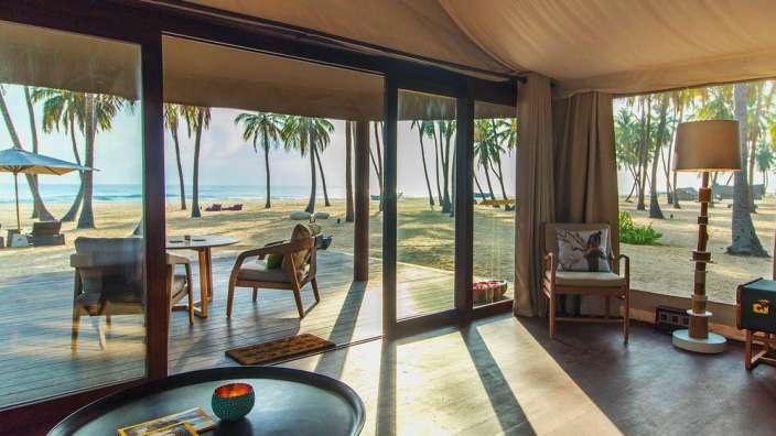 Ein Wohnzimmer mit vielen Fenstern und einem Tisch mit einem Buch darauf