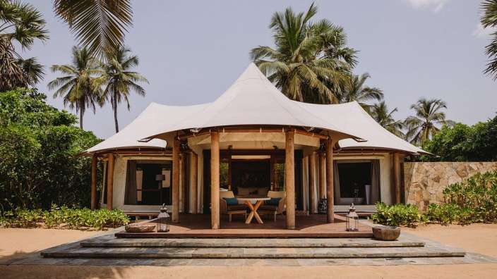 Ein weißes Zelt steht auf einem sandigen Strand