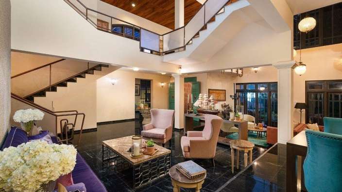 Ein Wohnzimmer mit vielen Möbeln und einer Treppe