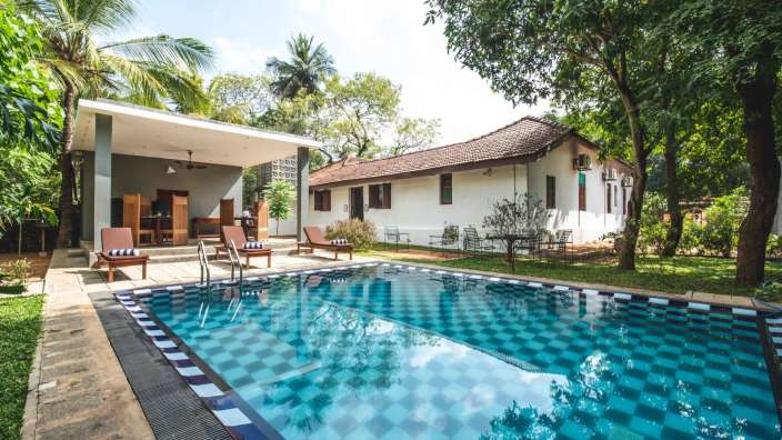 Ein großer Swimmingpool vor einem weißen Haus