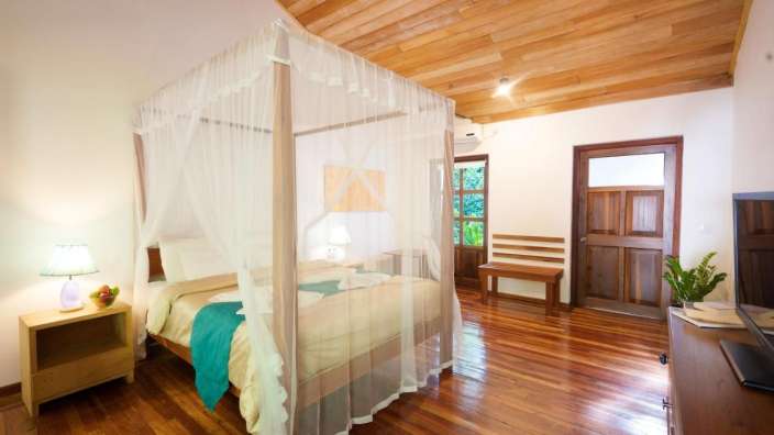 Ein Schlafzimmer mit Himmelbett und Holzboden