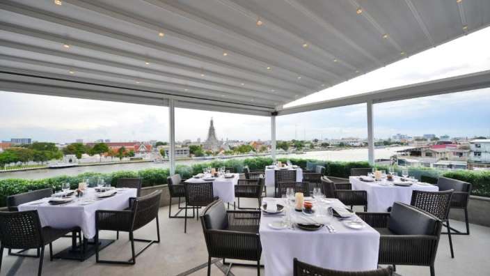 Tische und Stühle in einem Restaurant mit Blick auf den Fluss