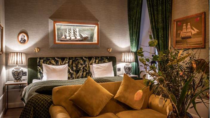 Ein Schlafzimmer mit einem Gemälde eines Schiffes an der Wand