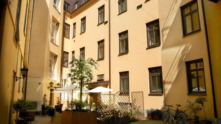 Ein Gebäude mit vielen Fenstern und einem kleinen Garten