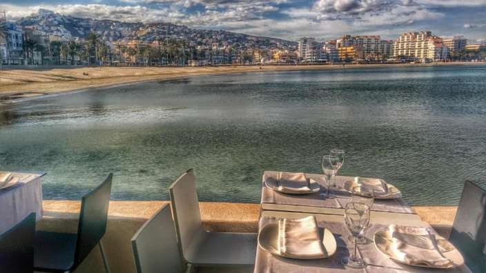 Ein Tisch mit Tellern und Gläsern in der Nähe des Wassers