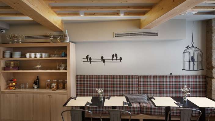 Ein Restaurant mit Tisch und Stühlen und einem Vogelkäfig an der Wand