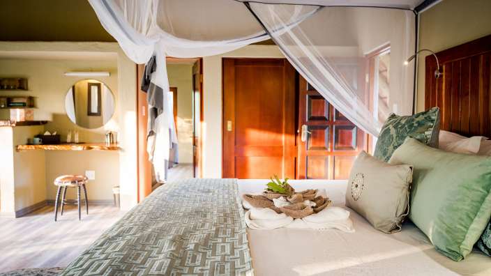 Ein Schlafzimmer mit einem Himmelbett und einem Spiegel