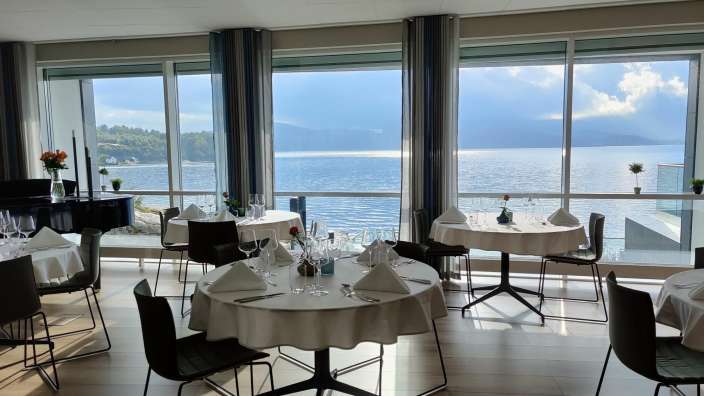 Tische und Stühle in einem Restaurant mit Blick auf den Ozean