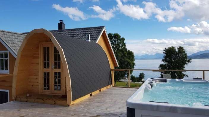 Ein Whirlpool steht auf einem Holzdeck neben einem Haus