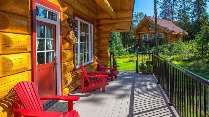 Eine hölzerne Kabine mit roten Stühlen auf der Veranda