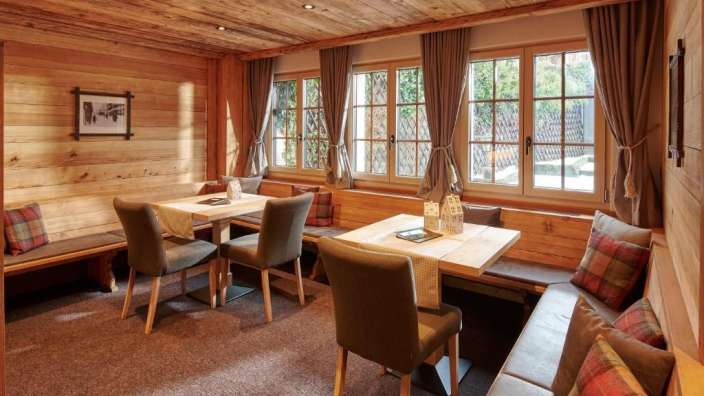 Ein Wohnzimmer mit Holzwänden und Stühlen und Tischen