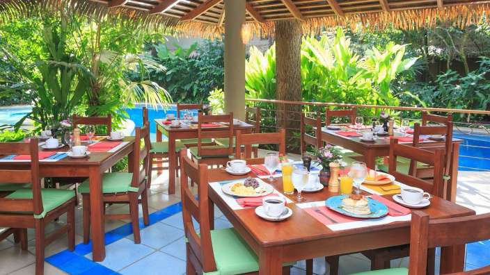 Tische und Stühle in einem Restaurant mit einem Pool im Hintergrund