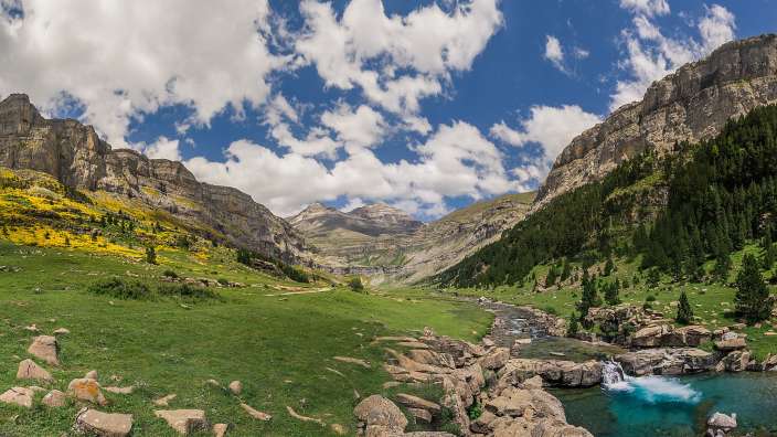 Ein Fluss fließt durch eine grüne Berglandschaft