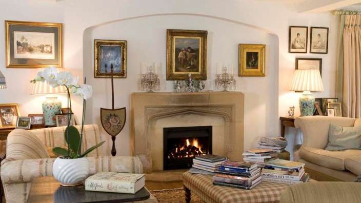 Ein Wohnzimmer mit einem Kamin und einem Stapel Bücher