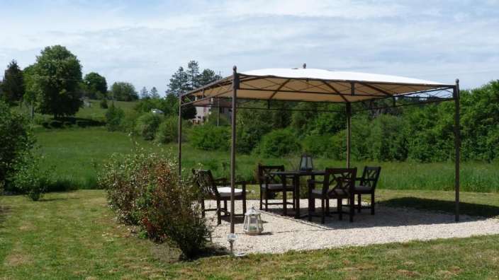 Ein Tisch und Stühle unter einem Zelt in einem Feld