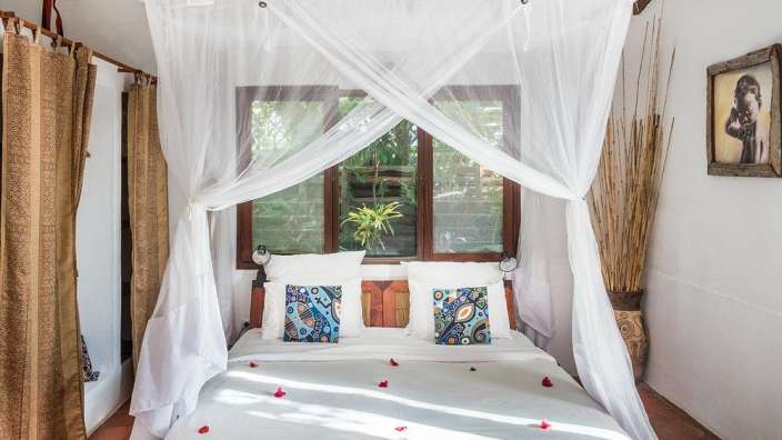 Ein Schlafzimmer mit einem Himmelbett und einem Fenster