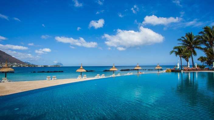 Ein riesiger Pool mit Sonnenschirmen und Stühlen am Strand