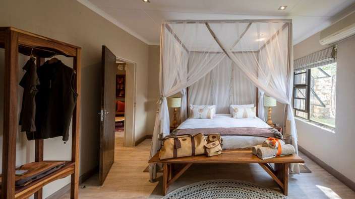 Ein Schlafzimmer mit einem Himmelbett und einer Bank