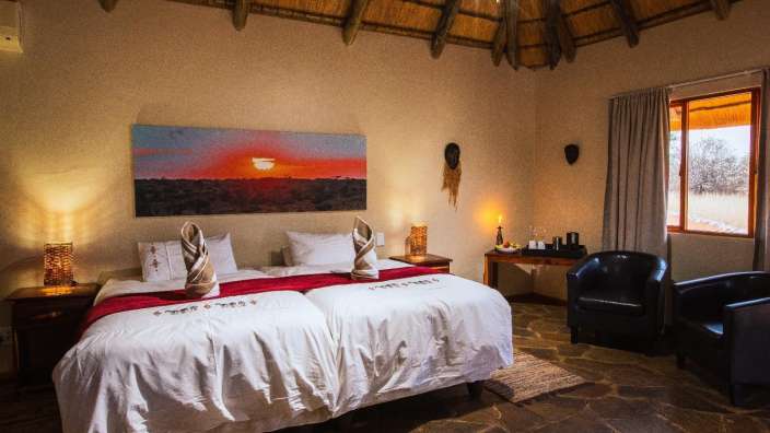 Ein Schlafzimmer mit zwei Betten und einem Gemälde an der Decke