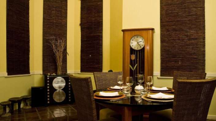 Ein Esszimmer mit einem Tisch und Stühlen und einer Uhr