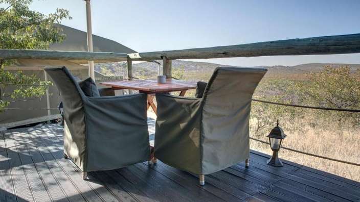 Zwei Stühle und ein Tisch auf einer Holzterrasse