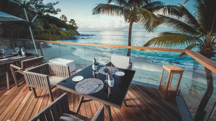 Ein Tisch und Stühle auf einem Deck mit Blick auf den Ozean