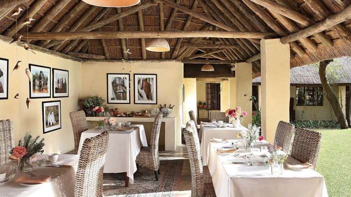 Ein Esszimmer mit Tisch und Stühlen und Bildern an der Wand