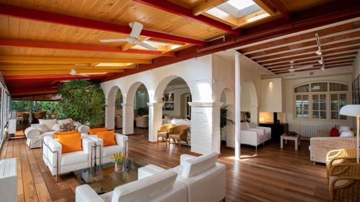 Ein Wohnzimmer mit weißen Möbeln und einem Deckenventilator