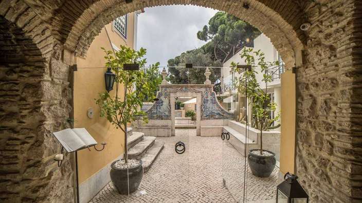 Ein bogenförmiger Eingang führt in einen kleinen Garten