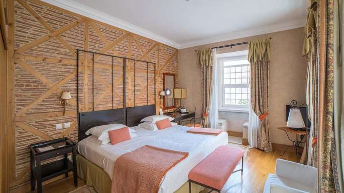 Ein Schlafzimmer mit zwei Betten und einer Ziegelwand