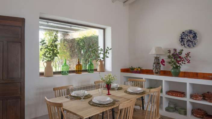 Ein Esszimmer mit einem Tisch und Stühlen und einem Fenster