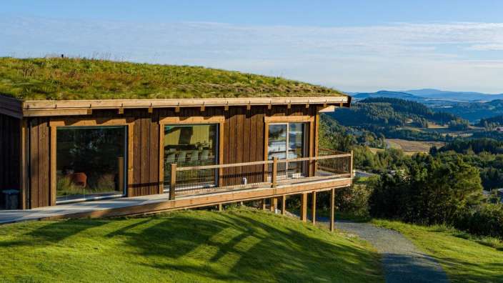 Ein kleines Holzhaus mit einem grünen Dach