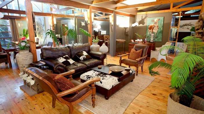Ein Wohnzimmer mit braunen Ledersofas und weißen Kissen