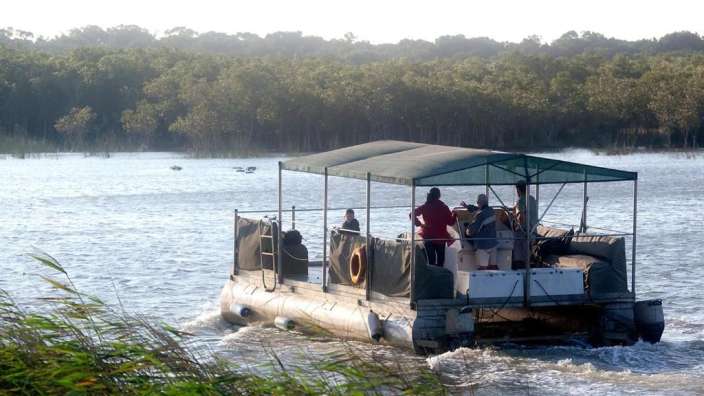 Eine Gruppe von Menschen fährt mit einem Boot auf einem Fluss