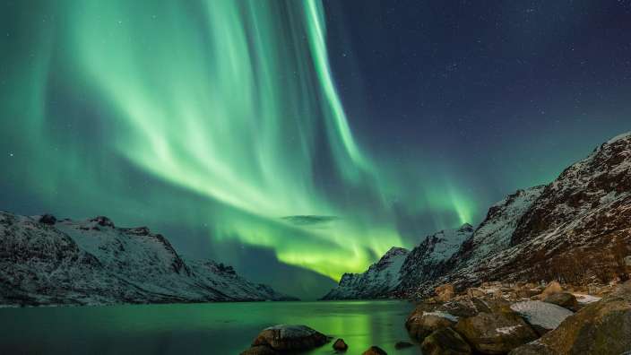 Das Nordlicht scheint über einen See in den Bergen