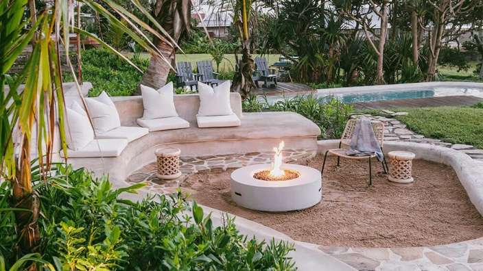 Ein weißer Feuerplatz in einem Garten neben einer Couch