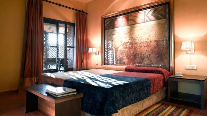 Ein Schlafzimmer mit zwei Betten und einem Gemälde an der Wand