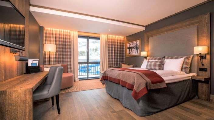 Ein Hotelzimmer mit einem großen Bett und einem Fernseher