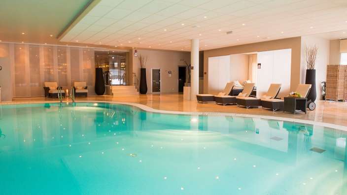 Ein großer Swimmingpool in einem Hotel mit Liegestühlen