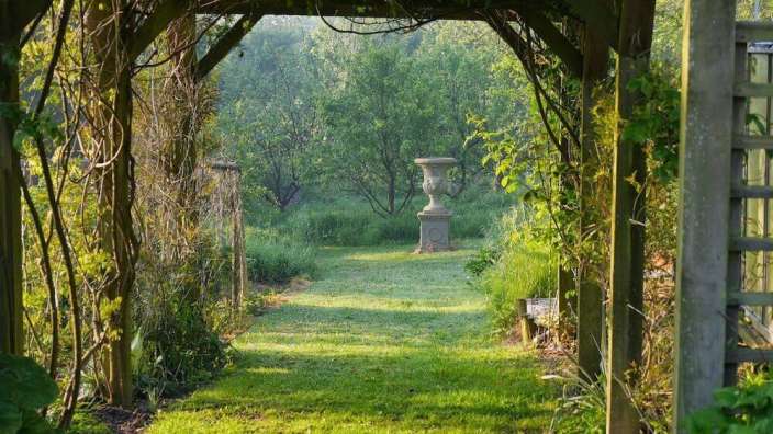 Ein Gartenweg mit einer Vase in der Mitte