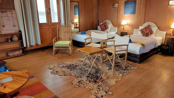 Ein Zimmer mit zwei Betten und einem Schaukelstuhl