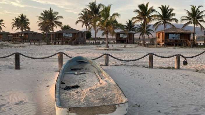 Ein weißes Boot sitzt auf einem sandigen Strand