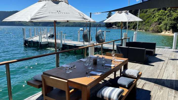 Ein Tisch und Stühle auf einem Dock mit zwei Flussschirmen